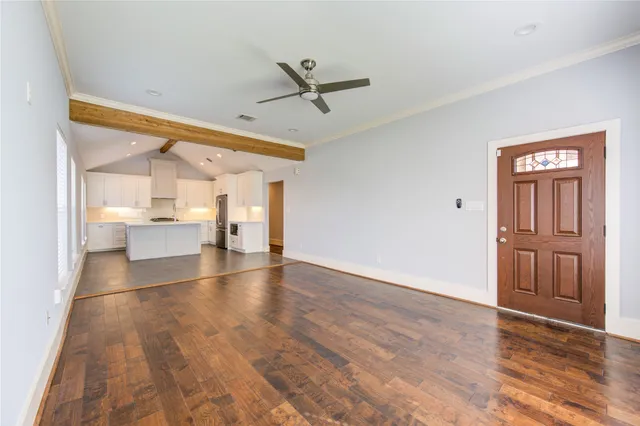 a view of a livingroom with wooden floor and a ceiling fan