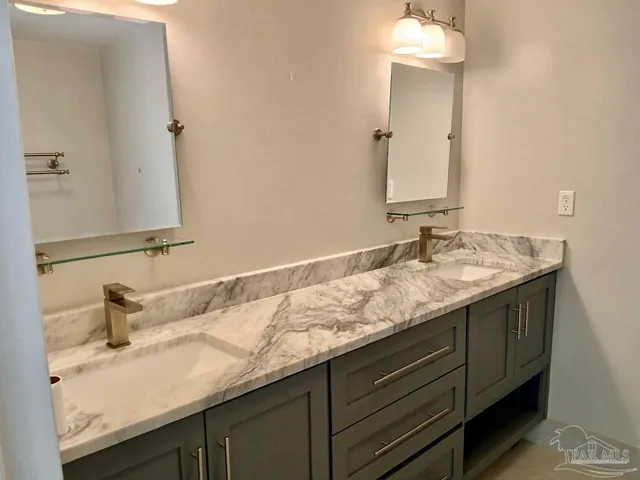 a bathroom with a granite countertop sink toilet and mirror