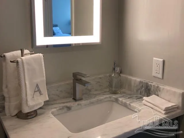 a bathroom with a granite countertop toilet and a sink