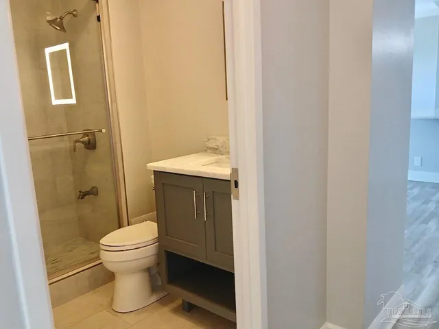 a bathroom with a granite countertop sink toilet and shower