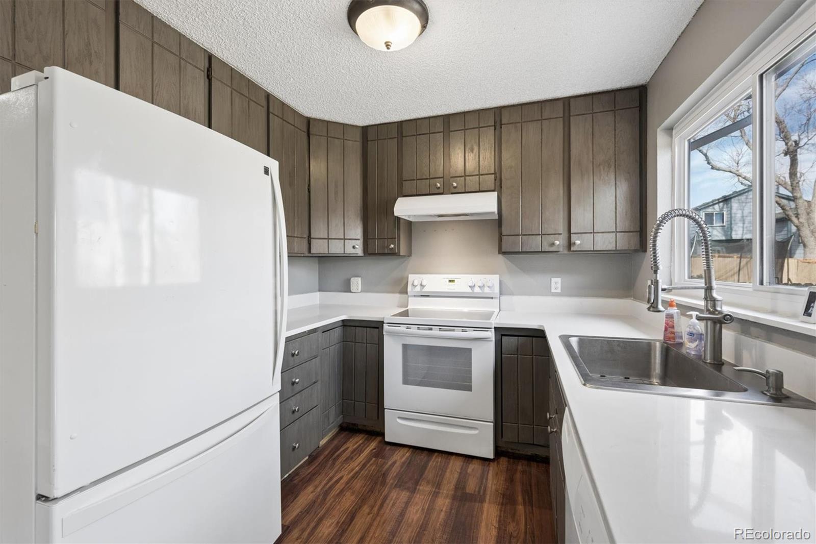 9802 Garrison Court Westminster, CO 80021 - Photo 13 of 34 a kitchen with a sink a stove and refrigerator