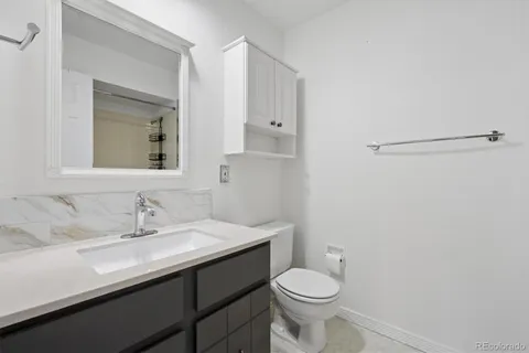 a bathroom with a sink a toilet and mirror