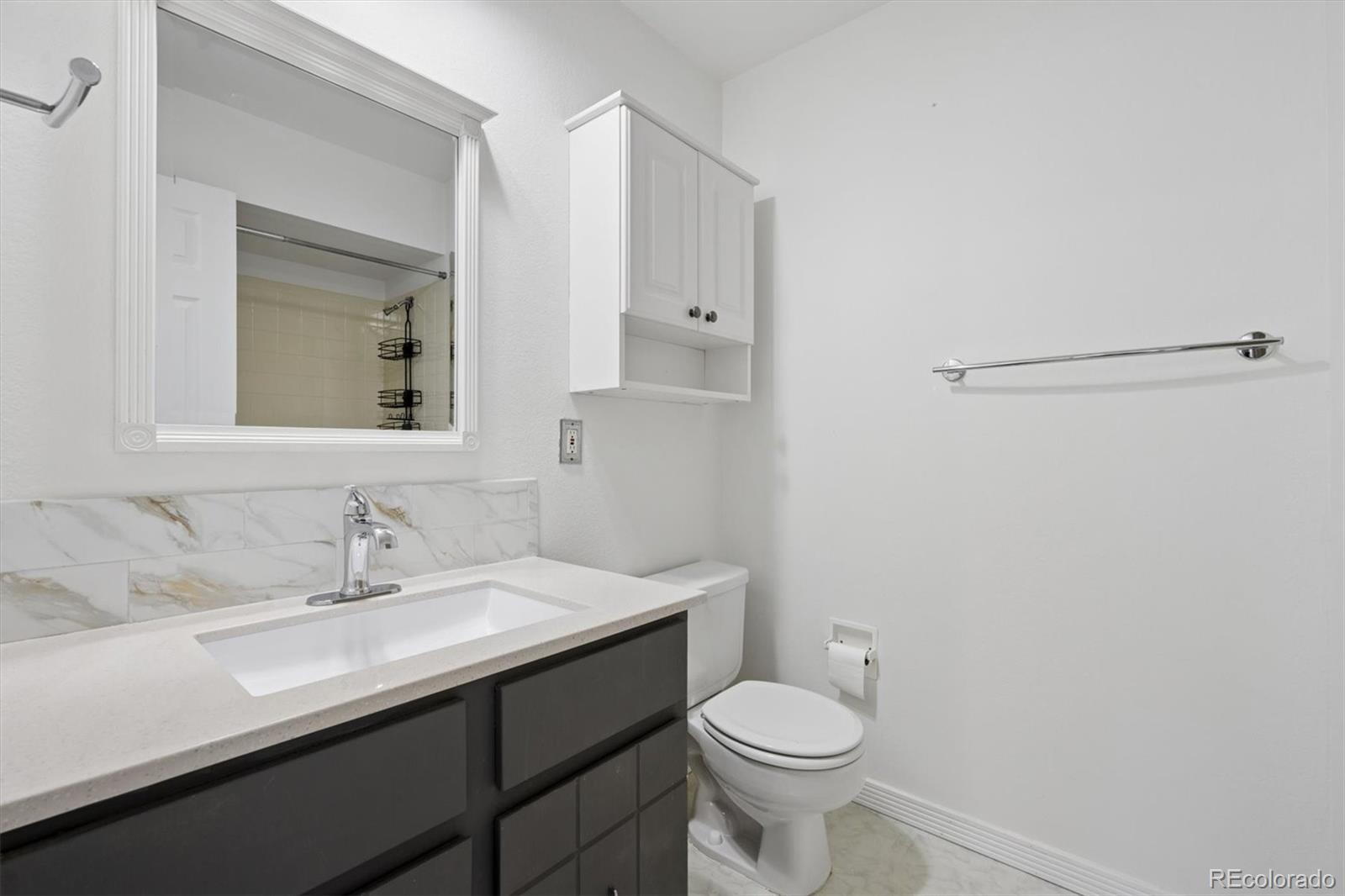 9802 Garrison Court Westminster, CO 80021 - Photo 25 of 34 a bathroom with a sink a toilet and mirror
