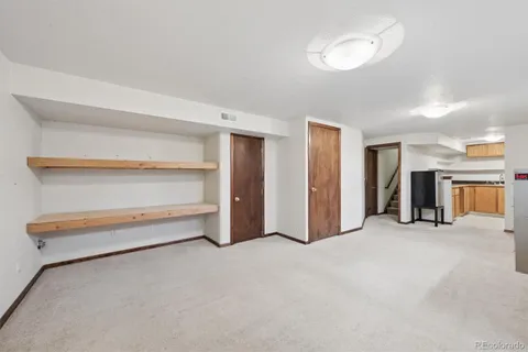 a view of an empty room with closet and a window