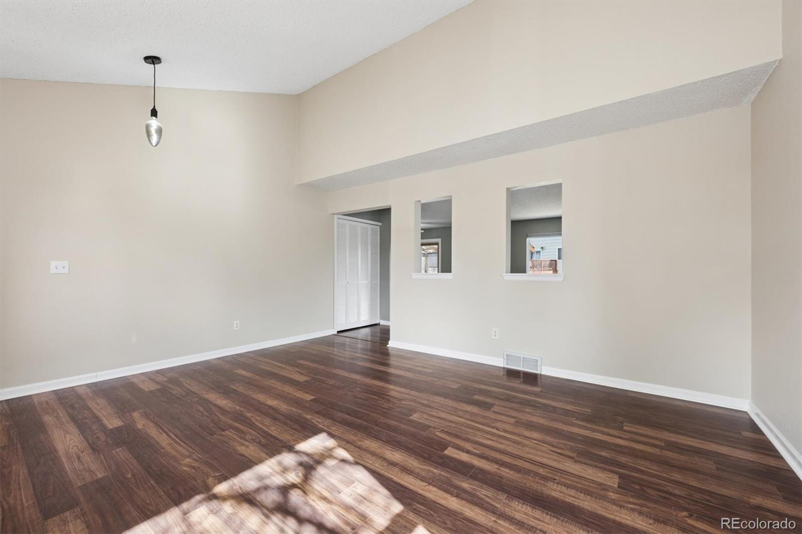 9802 Garrison Court Westminster, CO 80021 - Photo 3 of 34 a view of an empty room with wooden floor and a window