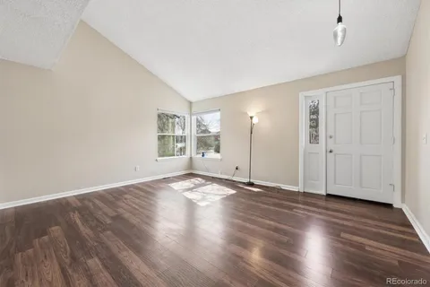 an empty room with wooden floor & windows and bathroom