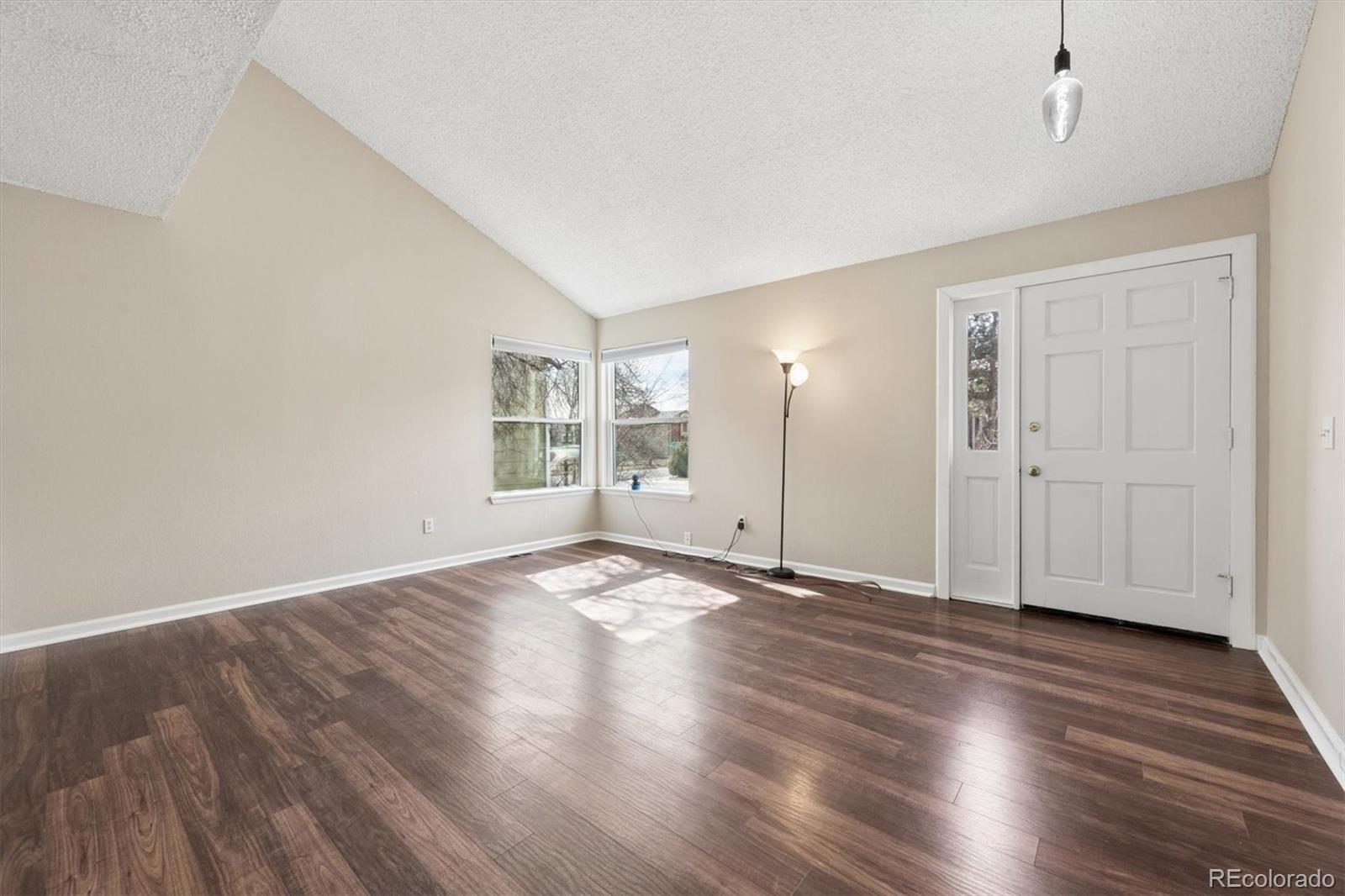 9802 Garrison Court Westminster, CO 80021 - Photo 4 of 34 an empty room with wooden floor & windows and bathroom