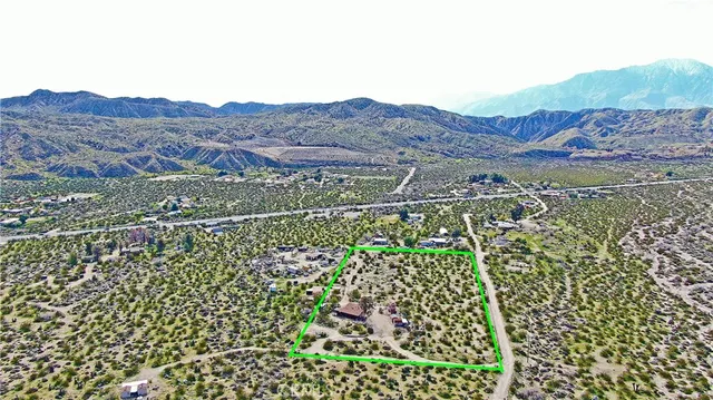 a view of a green field with mountains in the background