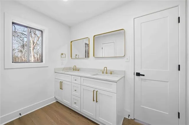 a spacious bathroom with 2 sink toilet and a mirror