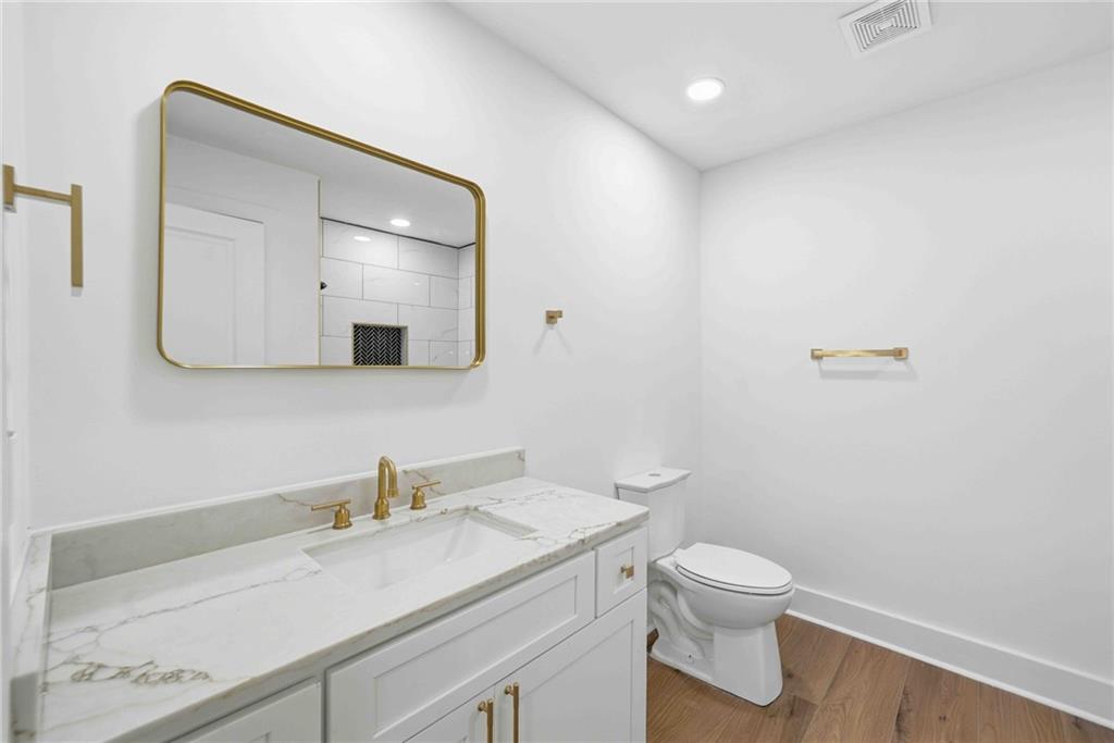 8975 Martin Road Roswell, GA 30076 - Photo 16 of 32 a bathroom with a granite countertop sink a toilet and a mirror