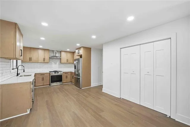 a large kitchen with stainless steel appliances granite countertop a large counter top a sink and a stove