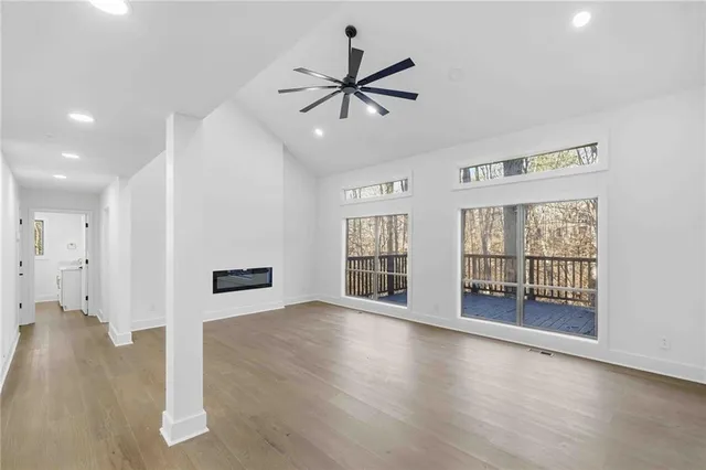 a view of an empty room with a window and wooden floor