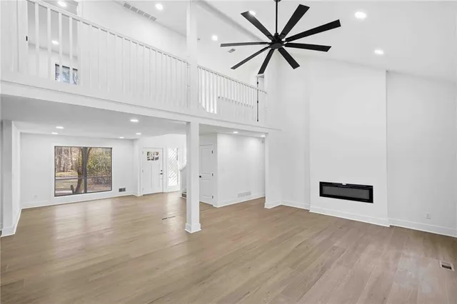 an empty room with wooden floor and a ceiling fan