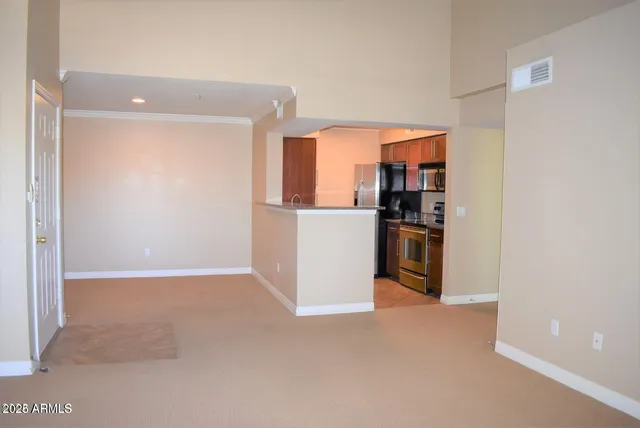 a view of a kitchen with an empty space and a refrigerator
