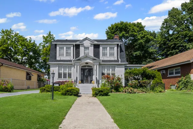 a front view of a house with a garden and plants