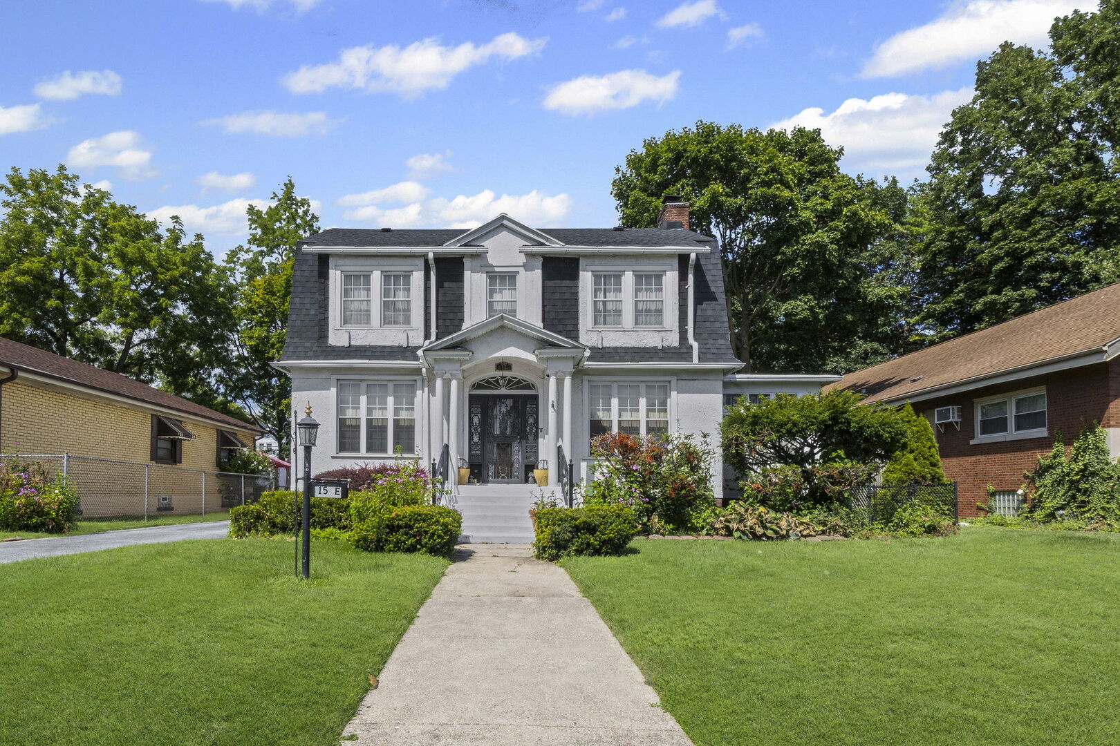 15 East 155th Street Harvey, IL 60426 - Photo 2 of 25 a front view of a house with a garden and plants