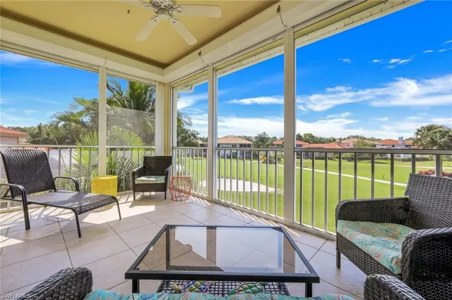 a living room with furniture floor to ceiling window and an outdoor view