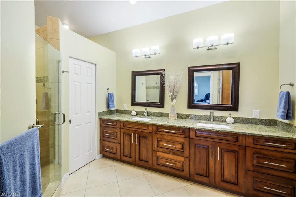 11384 Quail Village Way, Unit 203 Naples, FL 34119 - Photo 20 of 48 a bathroom with a granite countertop double vanity sink and a mirror