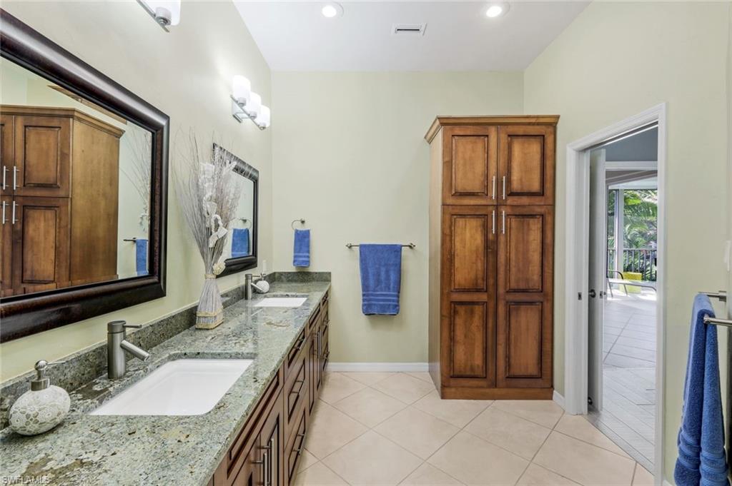 11384 Quail Village Way, Unit 203 Naples, FL 34119 - Photo 21 of 48 a bathroom with a granite countertop sink a mirror and a shower