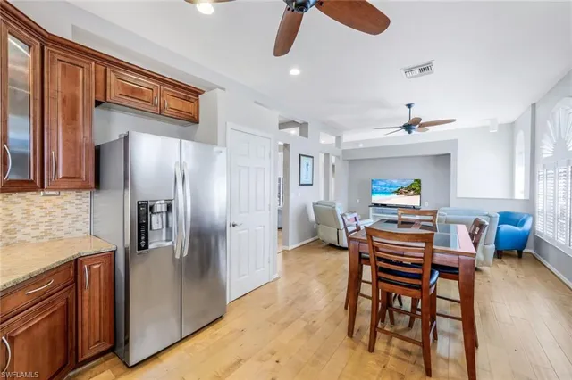 a kitchen with stainless steel appliances refrigerator dining table and chairs
