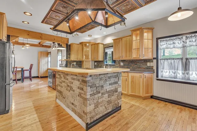 a large kitchen with kitchen island granite countertop a stove a sink and a refrigerator