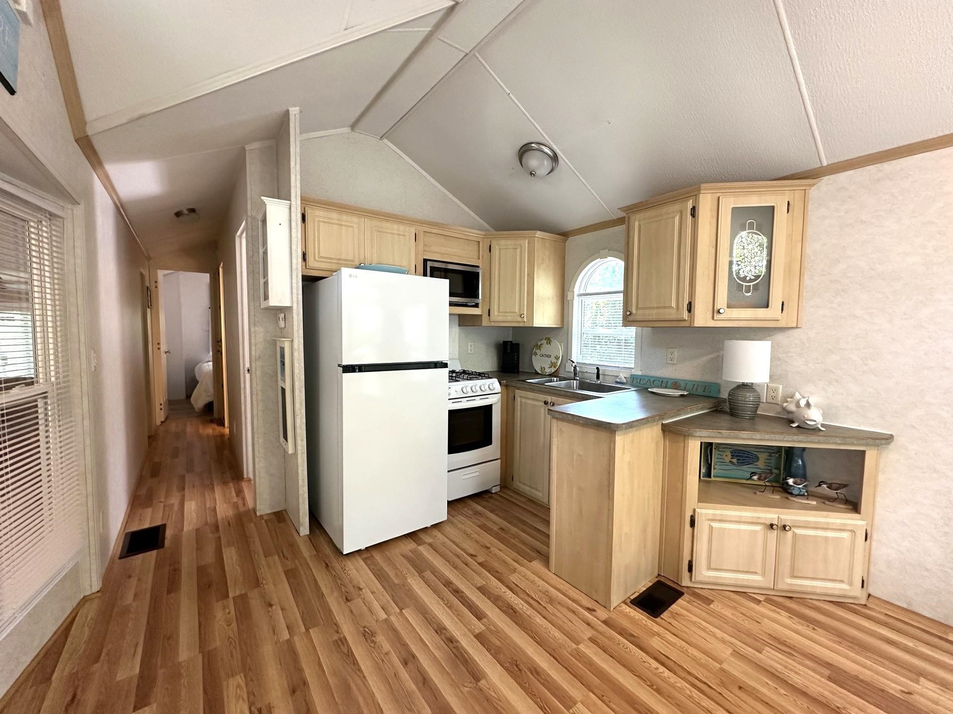 3066 North Rte 9 Ocean View, NJ 08230 - Photo 16 of 49 a kitchen with a refrigerator a stove top oven and wooden floors