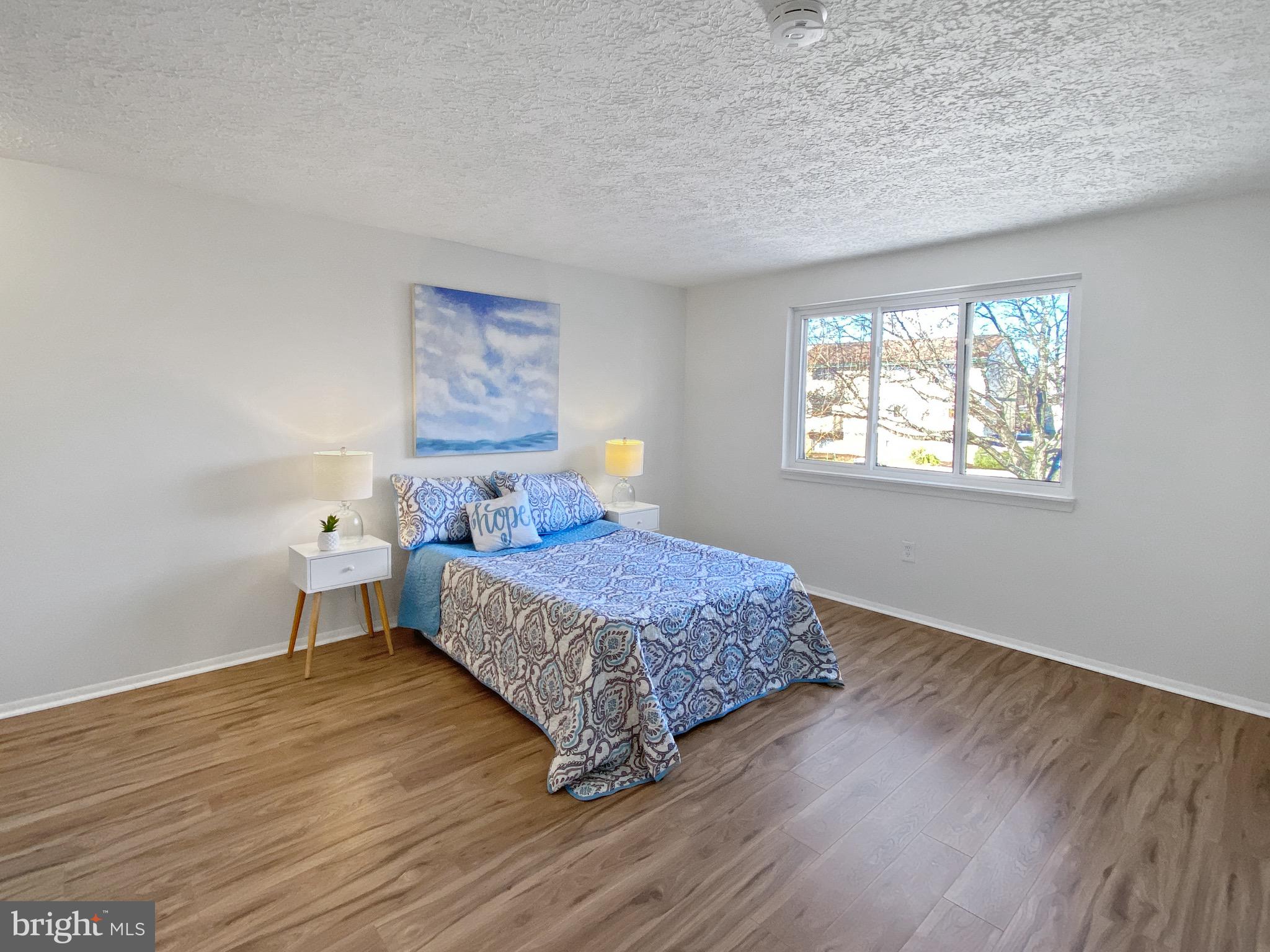 19525 Gunners Branch Road, Unit 222 Germantown, MD 20876 - Photo 9 of 15 a living room with a bed furniture and a window