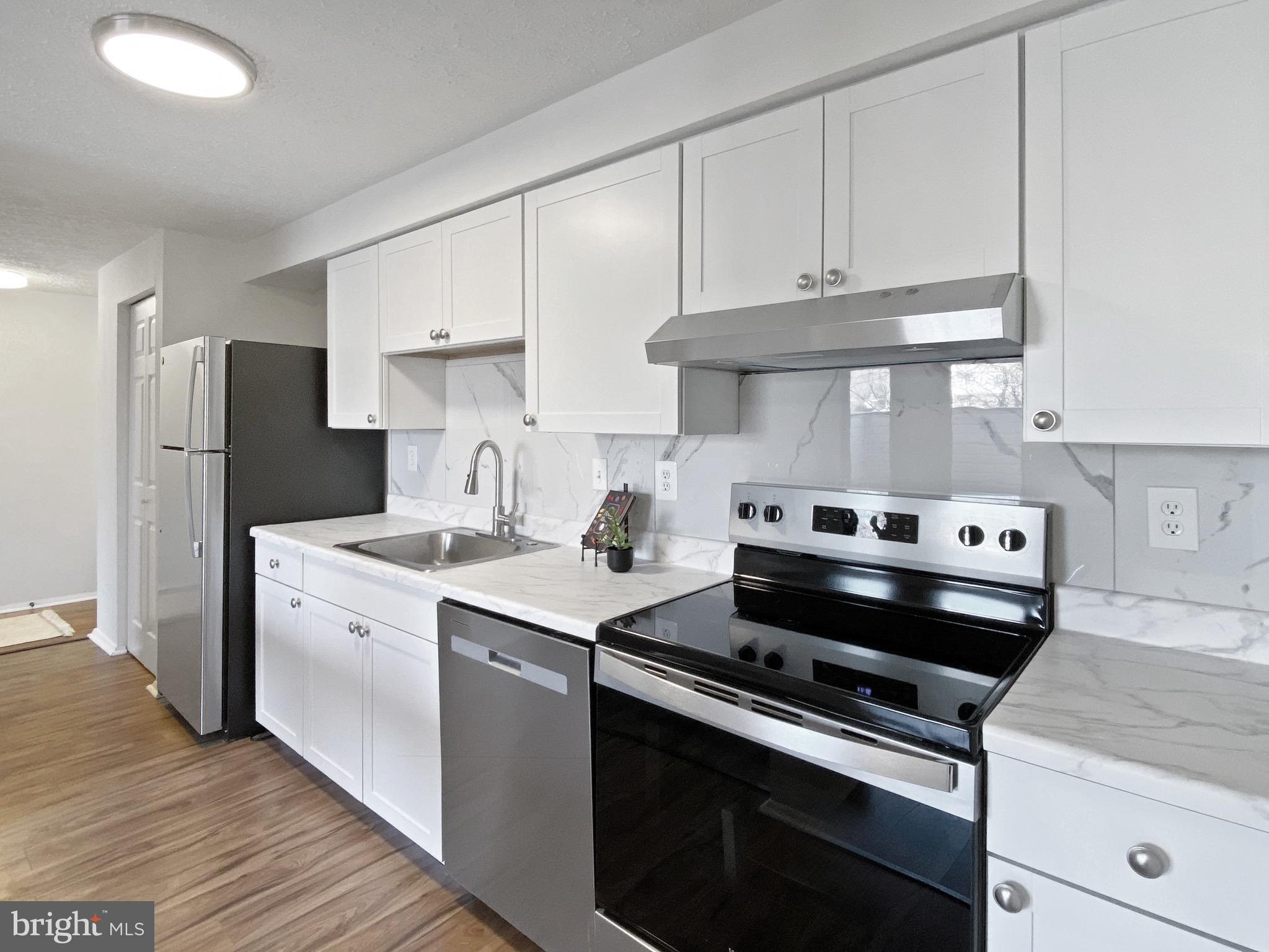 19525 Gunners Branch Road, Unit 222 Germantown, MD 20876 - Photo 2 of 15 a kitchen with a stove and a refrigerator