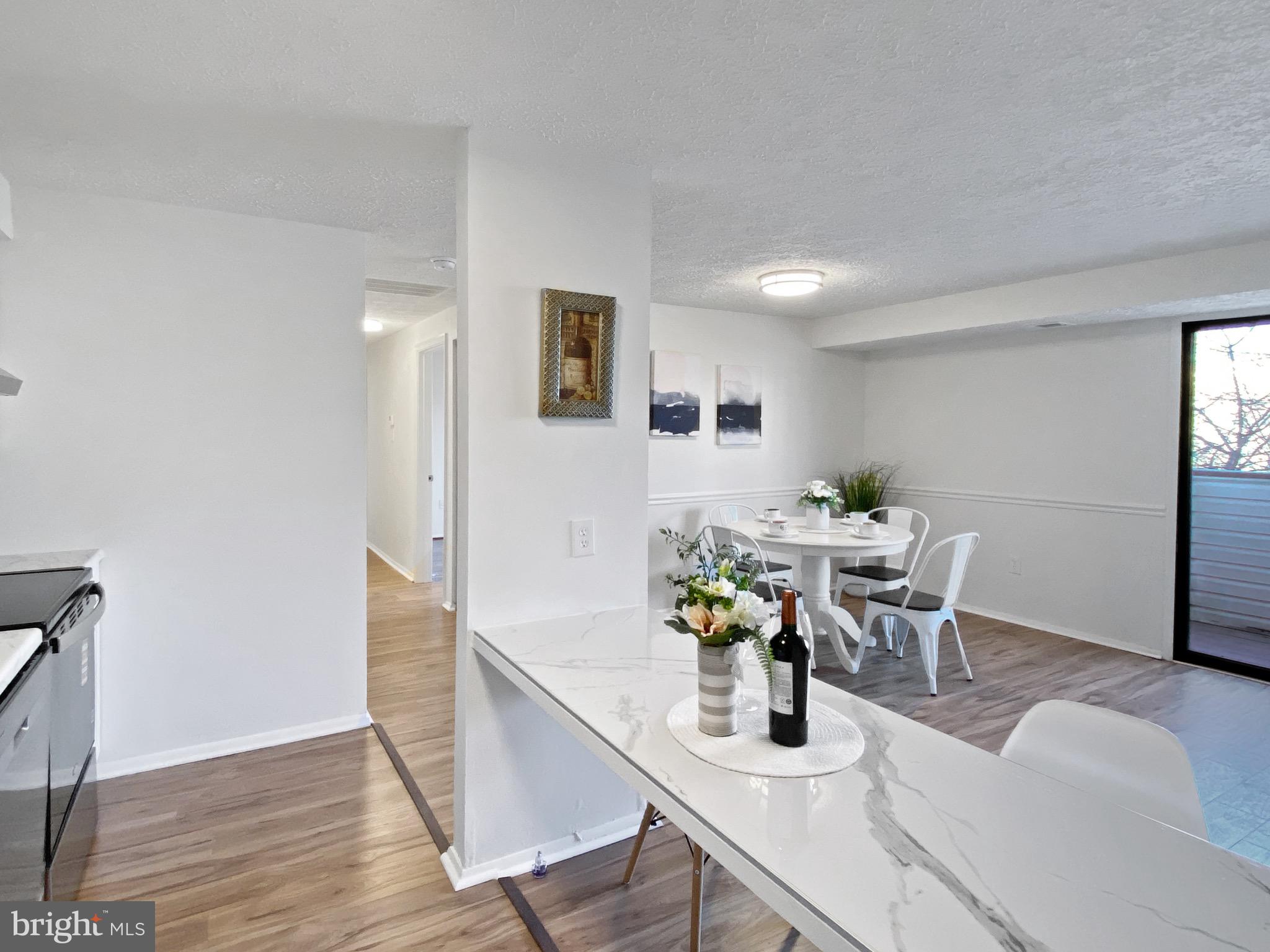 19525 Gunners Branch Road, Unit 222 Germantown, MD 20876 - Photo 14 of 15 a view of a dining room with furniture and wooden floor