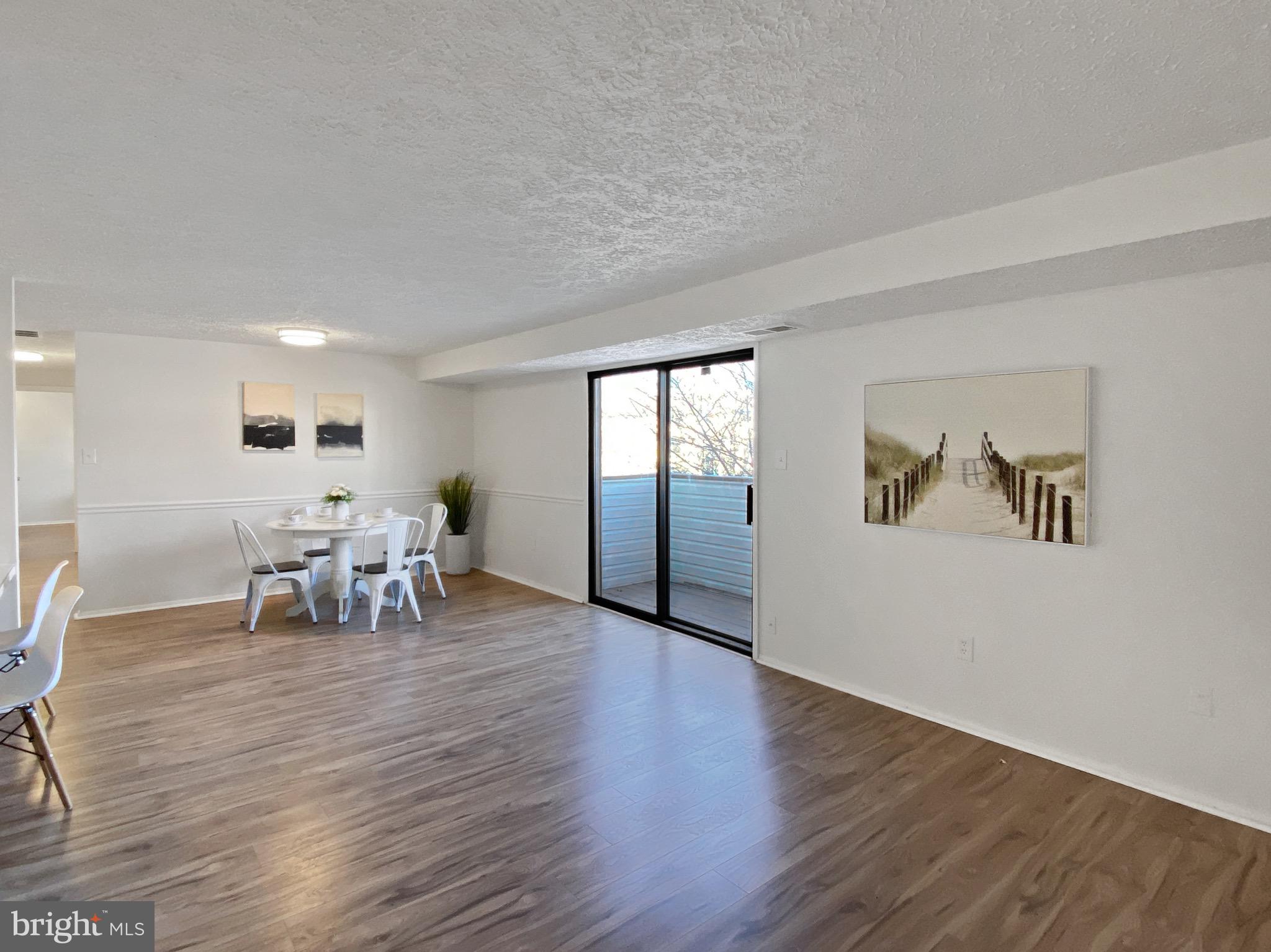 19525 Gunners Branch Road, Unit 222 Germantown, MD 20876 - Photo 5 of 15 a view of an empty room with wooden floor and a window