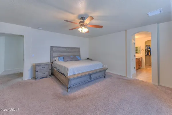 a spacious bedroom with a bed and a chandelier