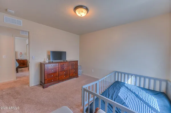 a bedroom with a chair and a window