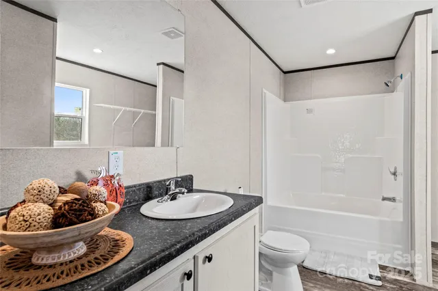 a bathroom with a granite countertop sink mirror toilet and bathtub