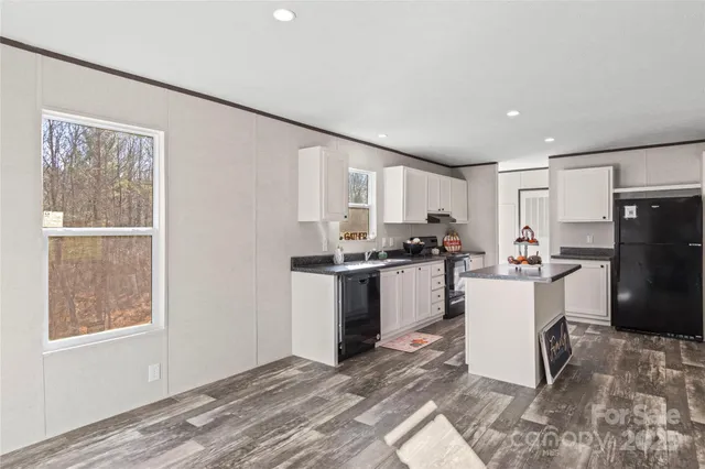 a kitchen with a refrigerator and white cabinets