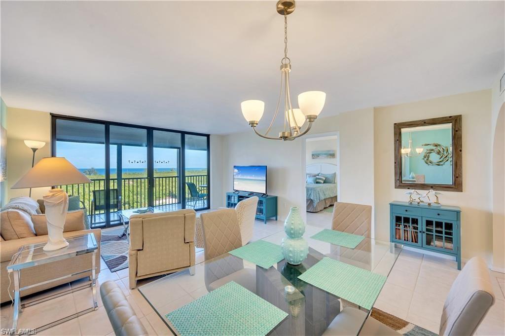 17 Bluebill Avenue, Unit 904 Naples, FL 34108 - Photo 18 of 20 a living room with furniture a chandelier and a floor to ceiling window