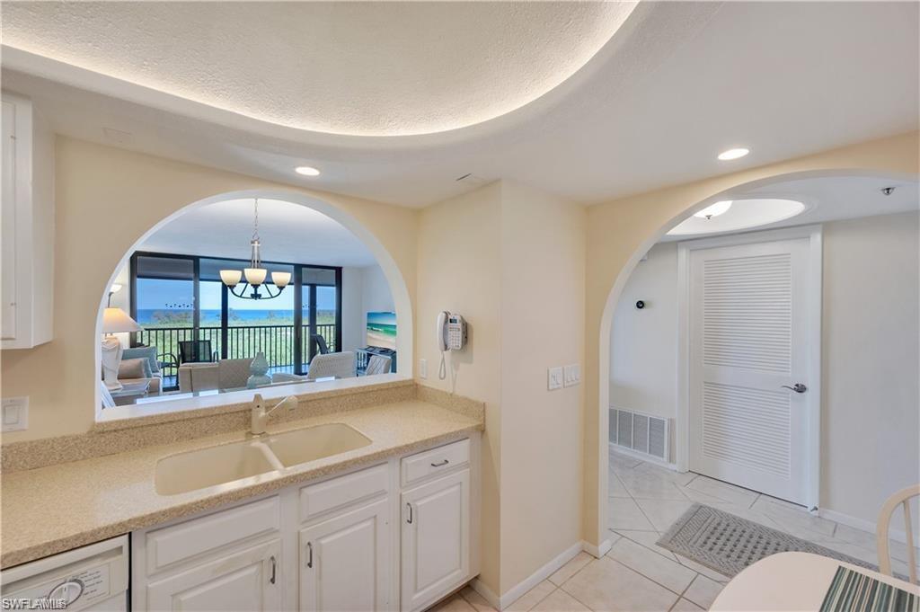 17 Bluebill Avenue, Unit 904 Naples, FL 34108 - Photo 19 of 20 a living room with a sink and chandelier