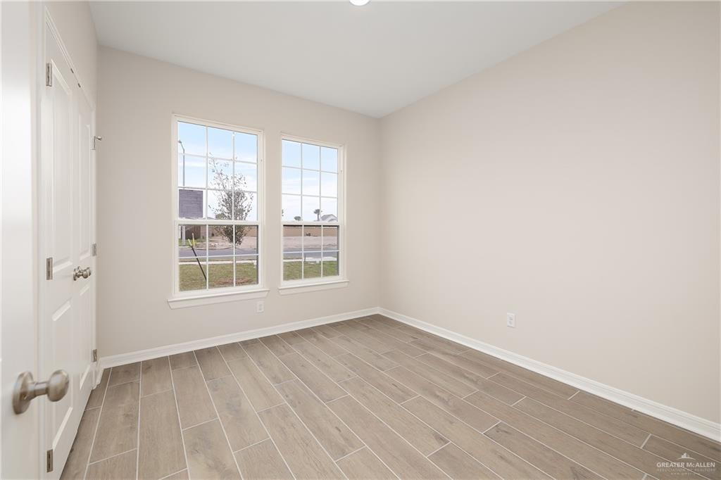 6600 Anaqua Loop McAllen, TX 78504 - Photo 11 of 16 an empty room with wooden floor and windows