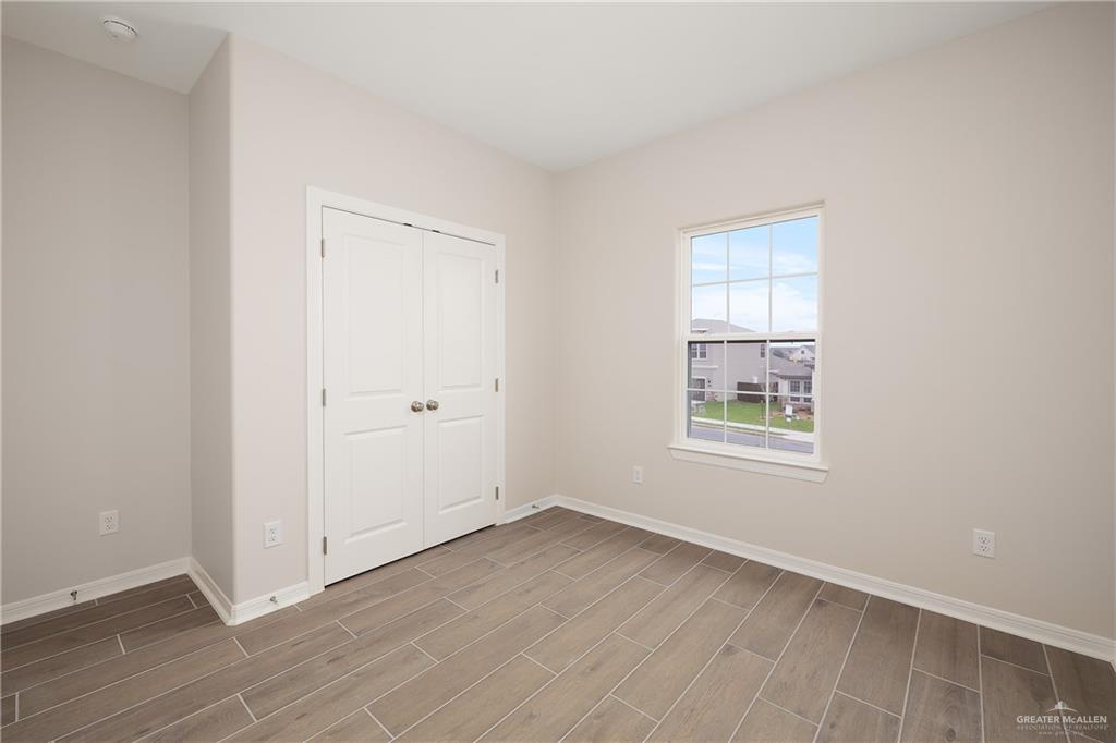 6600 Anaqua Loop McAllen, TX 78504 - Photo 15 of 16 an empty room with wooden floor and windows