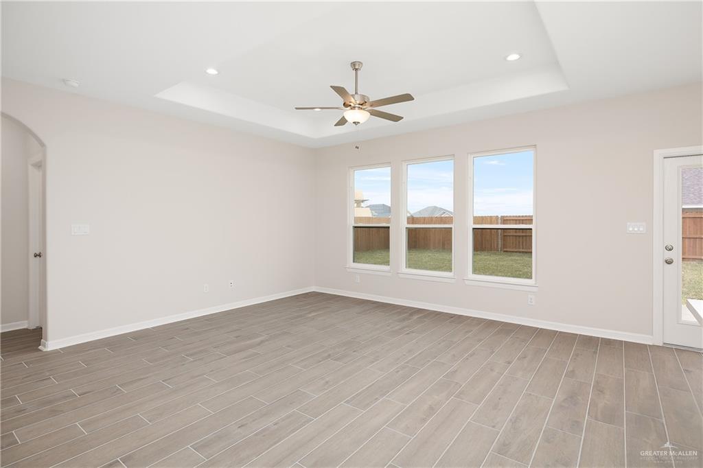 6600 Anaqua Loop McAllen, TX 78504 - Photo 2 of 16 an empty room with wooden floor ceiling fan and windows