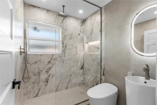 a bathroom with a toilet a sink and shower