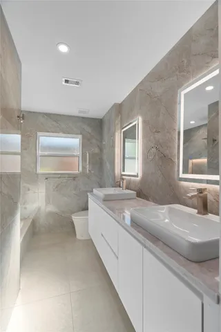 a bathroom with double vanity sinks and a bathtub