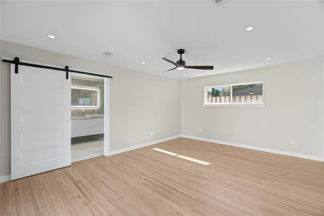 a view of a livingroom with wooden floor and a ceiling fan