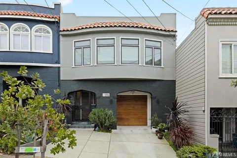 a front view of a house with plants