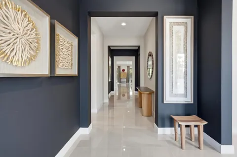 a view of a hallway with furniture and a window