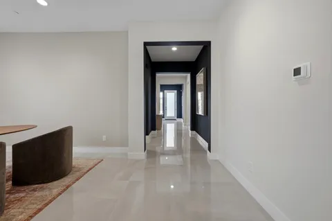 a view of a hallway with wooden floor and a fireplace
