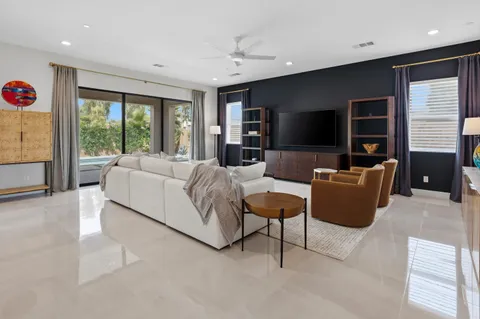 a living room with furniture tv and large window