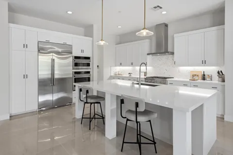 a kitchen with kitchen island a counter top space appliances and cabinets