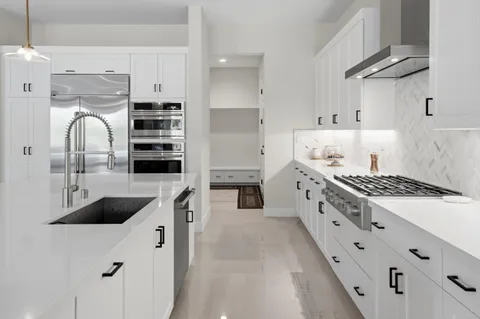a kitchen with stainless steel appliances a stove a sink and a refrigerator
