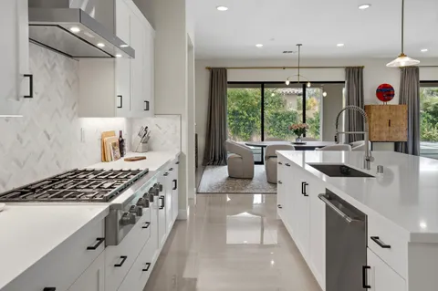 a kitchen with kitchen island a sink appliances and a counter top space