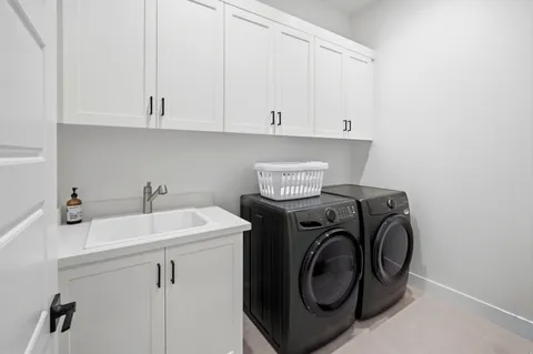 a utility room with sink dryer and washer